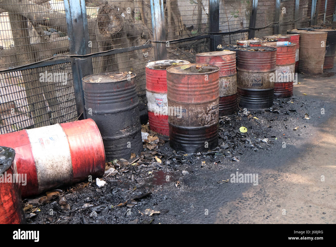 Il vecchio barile arrugginito a sinistra nella strada perde spesso nero catrame o olio su una strada urbana in Kolkata, India del 10 febbraio, 20 Foto Stock