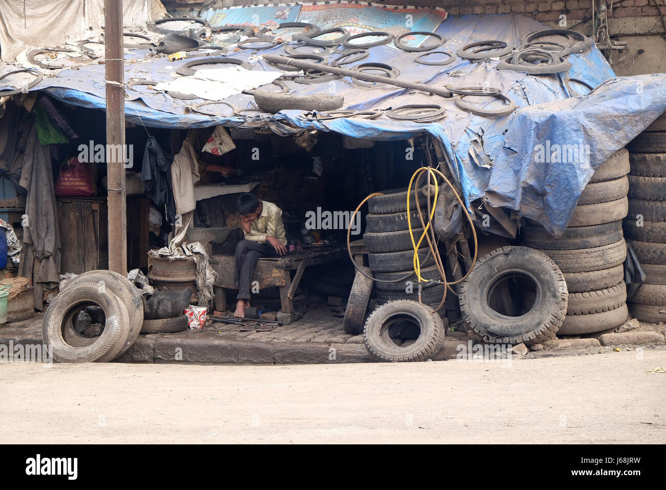 Un pneumatico di servizio di sostituzione. Un vasto numero di veicoli in India sono serviti da tali imprese locali. Kolkata, India su Foto Stock