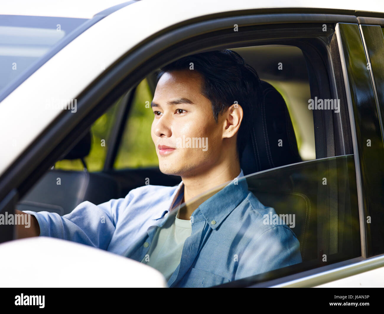 Giovani asiatici uomo alla guida di un veicolo. Foto Stock