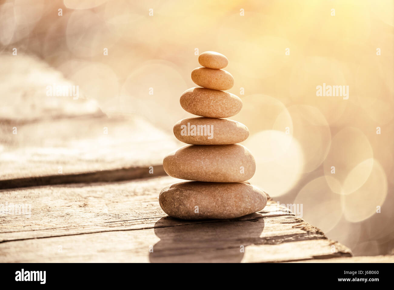 Spa pietre ancora la vita sulla spiaggia, stack di ciottoli sul lungomare oltre il mare nella luce del tramonto, la pace e il relax di una vacanza estiva, equilibrio in li Foto Stock