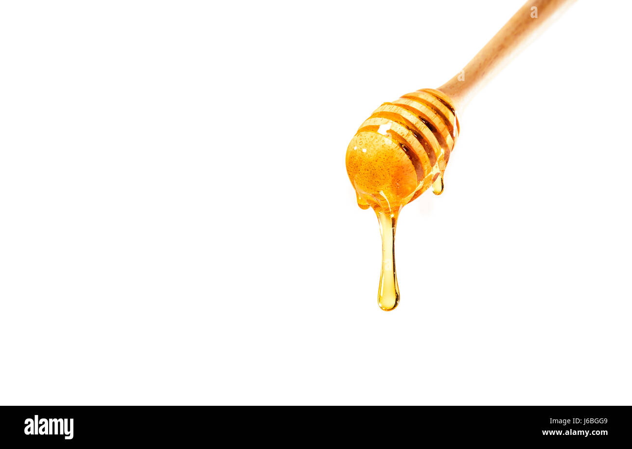Miele di gocciolamento sulla cucchiaia di legno sfondo bianco con camera per spazio di copia Foto Stock