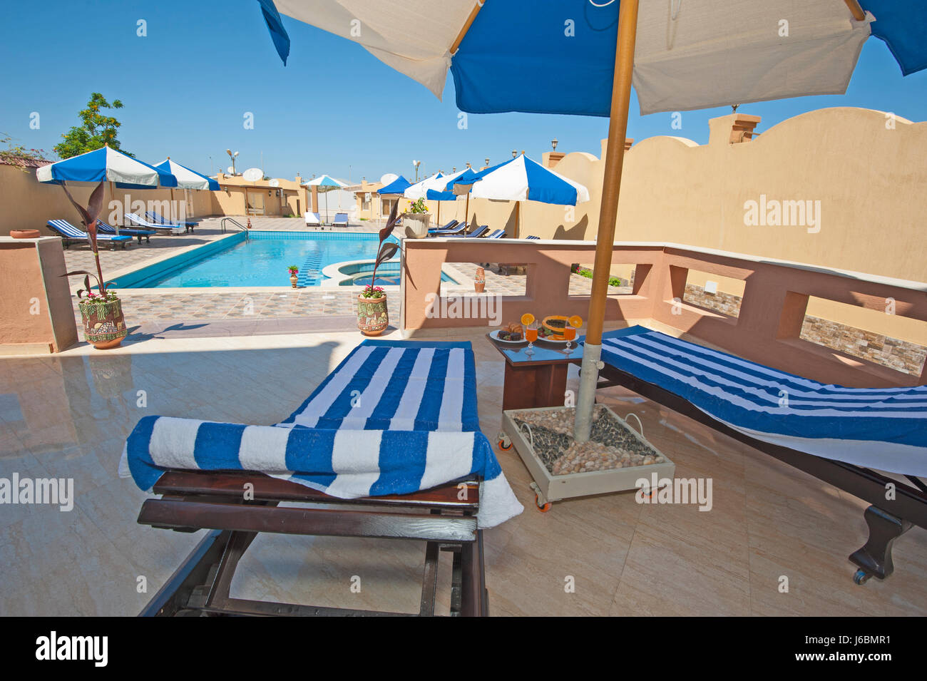 Villa di lusso show home in estate tropicale resort per vacanze con piscina e lettini per prendere il sole Foto Stock