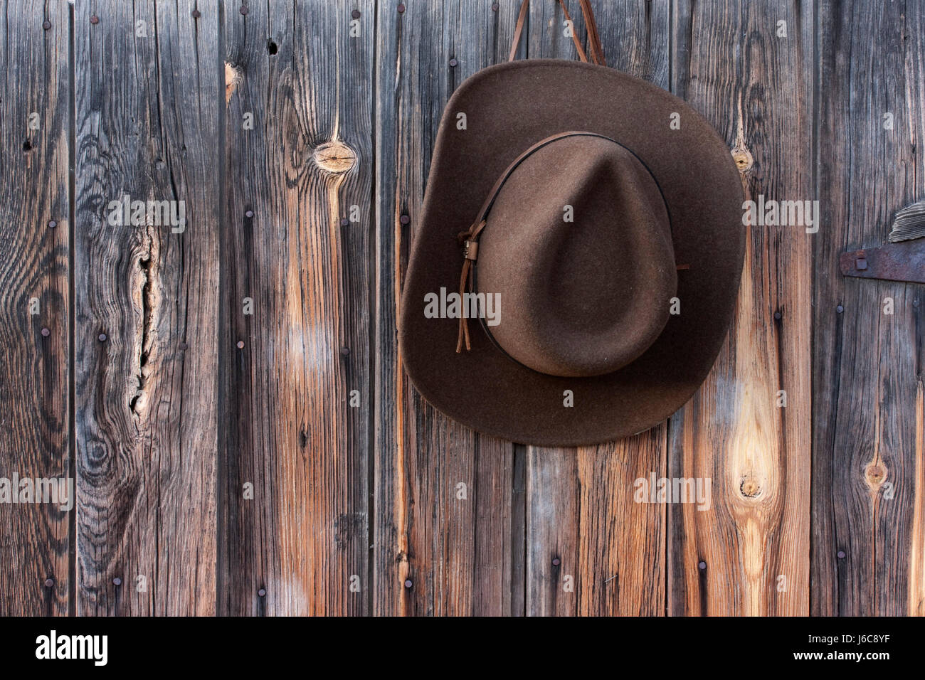 Legno hat fienile di lana feltro cowboy appeso riagganciare il legno ruvido hat parete in pelle Foto Stock