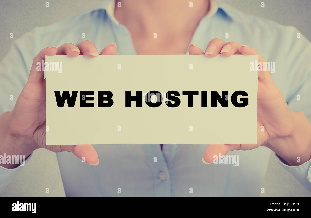 Business donna mani carta bianca segno con web hosting messaggio di testo isolato sul muro grigio office background. Retrò stile instagram immagine. Techn Foto Stock