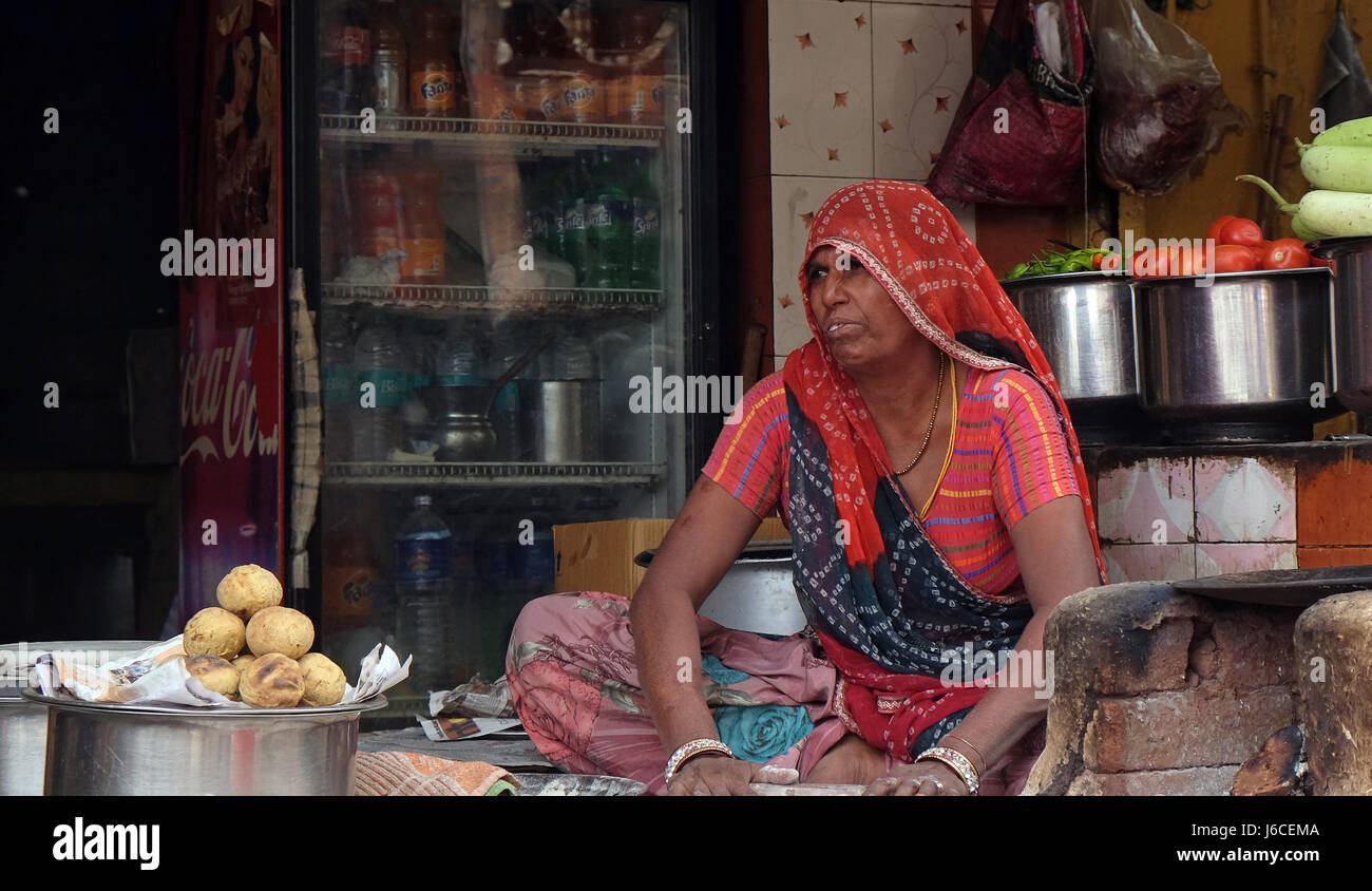 Una donna indiana fritto vendita di cibo di strada in una strada di Pushkar, Rajasthan, India il 17 febbraio 2016. Foto Stock