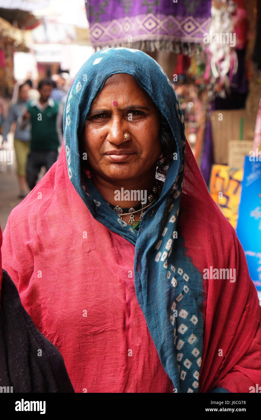 Donna indiana con velo colorato e sari e un naso gioielli in posa sulla strada di Pushkar, Rajasthan, India Foto Stock
