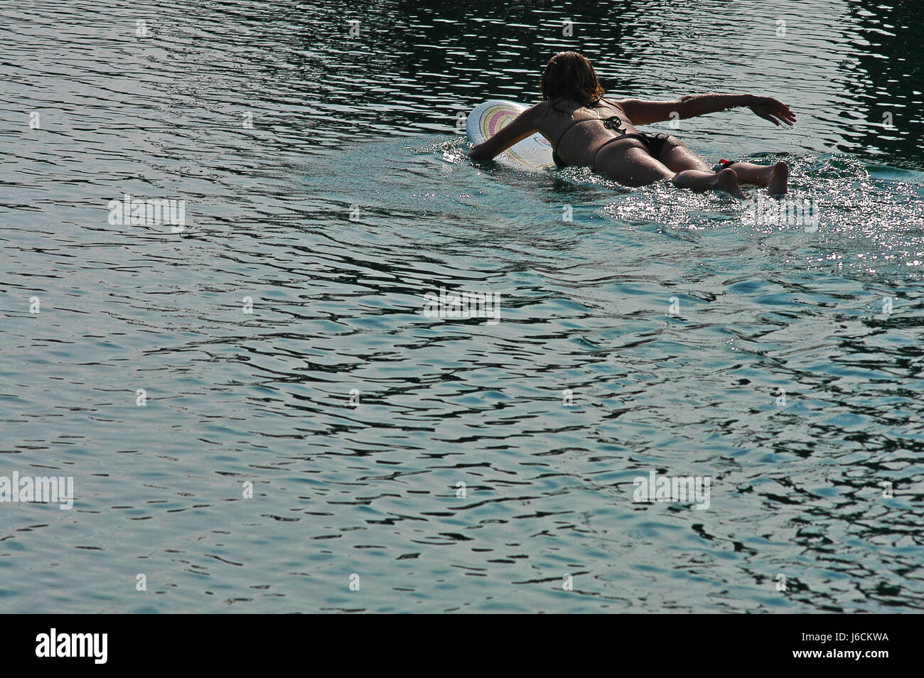 Donna Summer summerly giacciono giacente giace contro-luce ombreggiata acqua di sale di mare Foto Stock