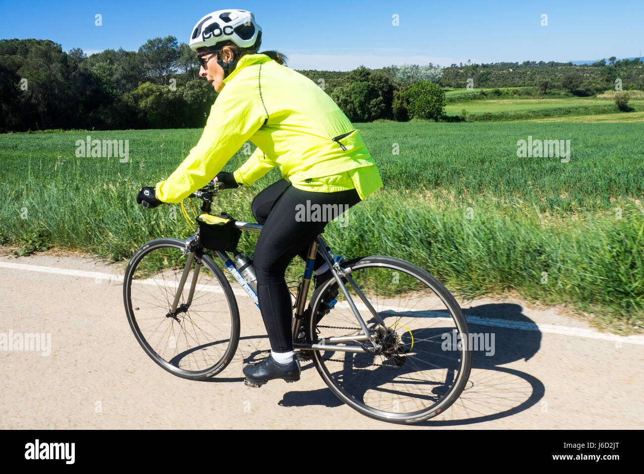 Una femmina di touring ciclista in sella la sua bicicletta titanio nelle campagne della provincia di Girona, Spagna. Foto Stock