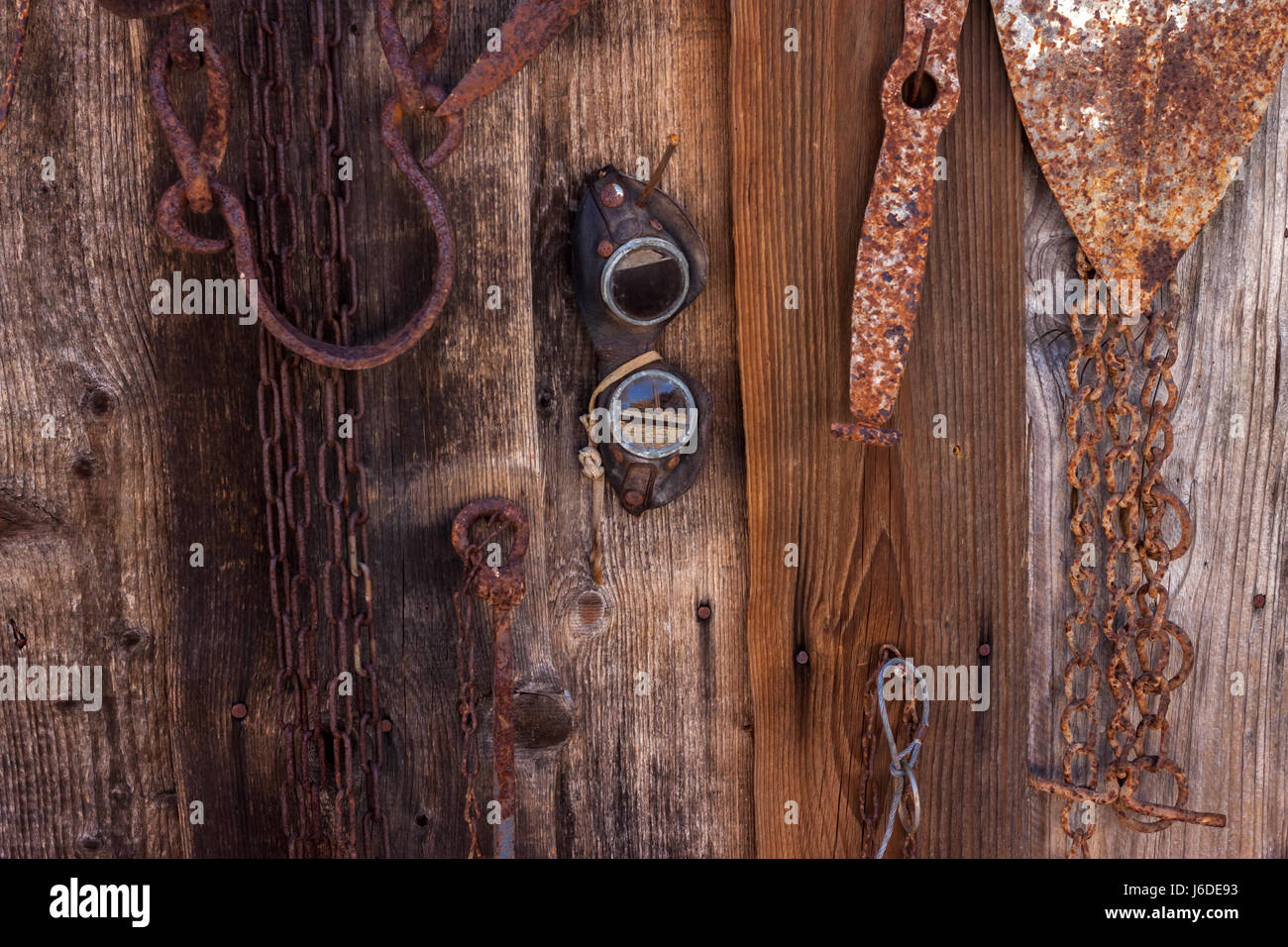 Strumenti agricoli appesi marrone parete in legno Foto Stock