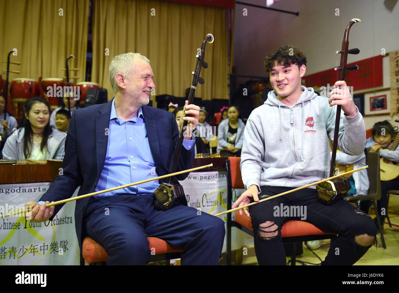 Leader laburista Jeremy Corbyn (sinistra con Charlie Wardle, 17, giocando un erhu durante una comunità visita alla Pagoda arti di Liverpool come il generale campagne elettorali è in pausa per il giorno di onore assassinato MP Jo Cox concentrandosi su ciò che i politici hanno in comune. Foto Stock
