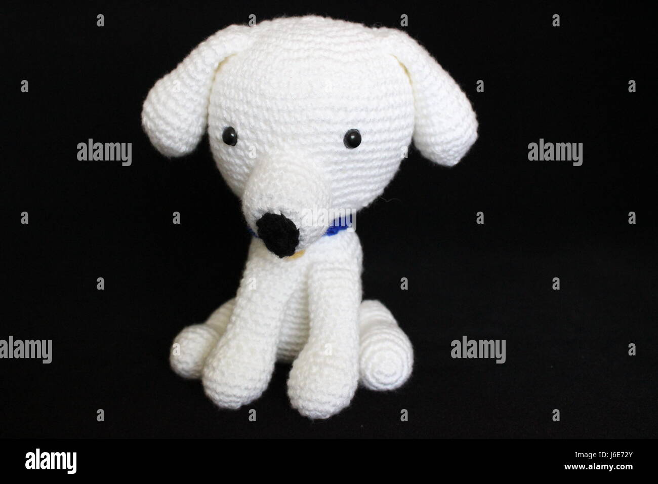 Bianco Giocattolo del cane a maglia poste su sfondo nero Foto Stock