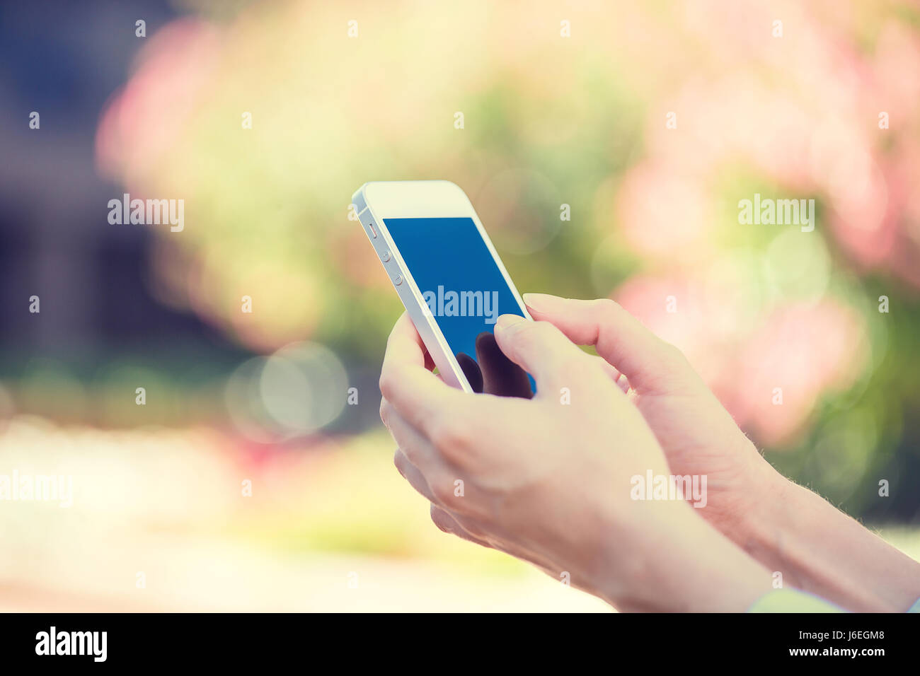 Immagine closeup donna mani, utilizzando smart, telefono cellulare isolato al di fuori della città sullo sfondo. Nuova generazione di tecnologia, persone dipendenza telefono conce Foto Stock