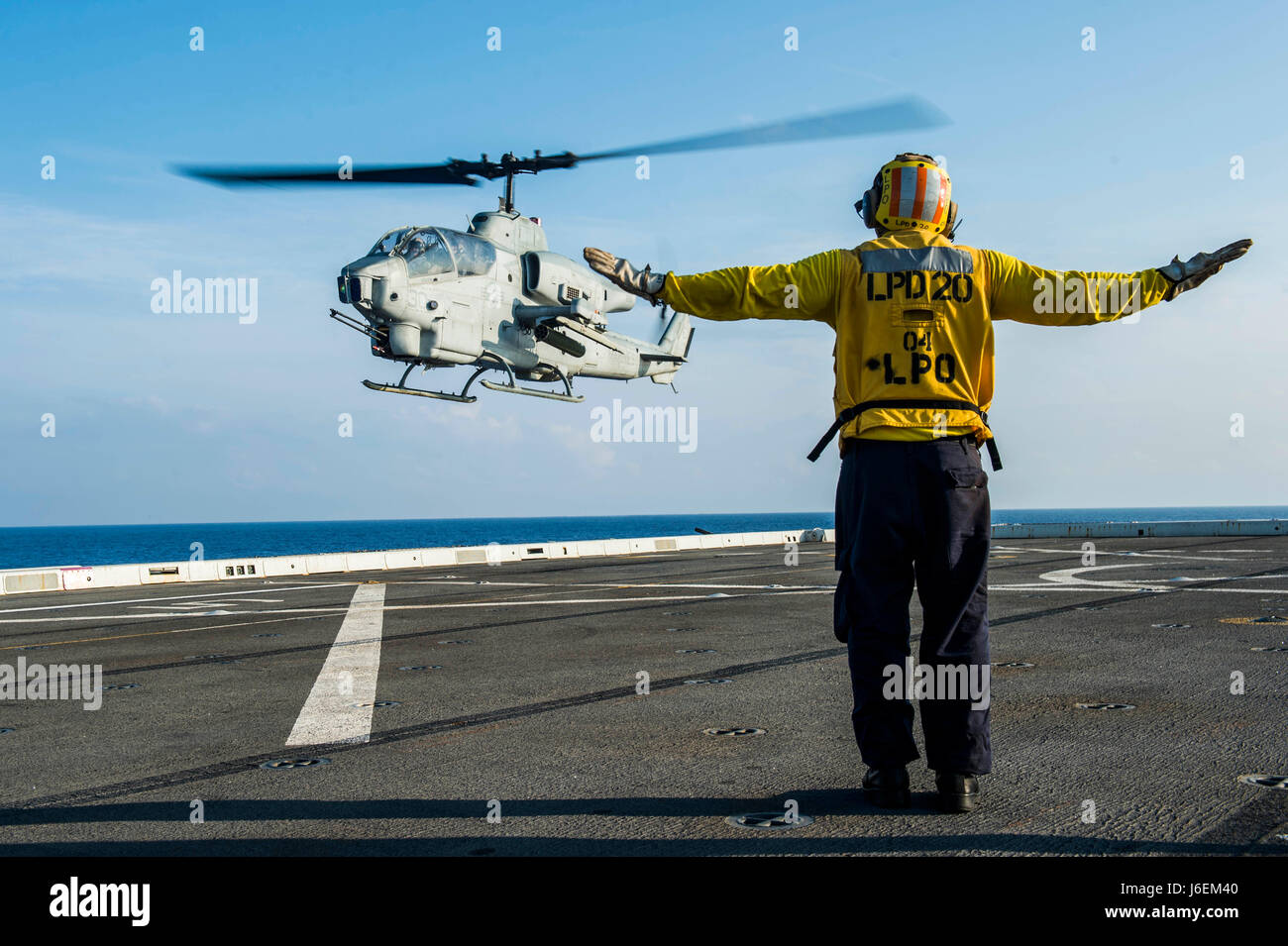 Mare delle Filippine (Agosto 23, 2016) di aviazione di Boatswain Mate (manipolazione) 1a classe Patrick Henry, da Pearl City, Hawaii, segnali ad un AH-1W Super elicottero Cobra, assegnato a mezzo marino Tiltrotor Squadron (VMM) 262 (rinforzato), come si atterra sul ponte di volo del trasporto anfibio dock nave USS Green Bay (LPD 20). Green Bay, parte dell'Bonhomme Richard Expeditionary Strike gruppo, è operativo negli Stati Uniti 7 flotta area di operazioni a sostegno della sicurezza e della stabilità in Indo-Asia-regione del Pacifico. (U.S. Foto di Marina di Massa lo specialista di comunicazione di terza classe Patrick Dionne/rilasciato) Foto Stock