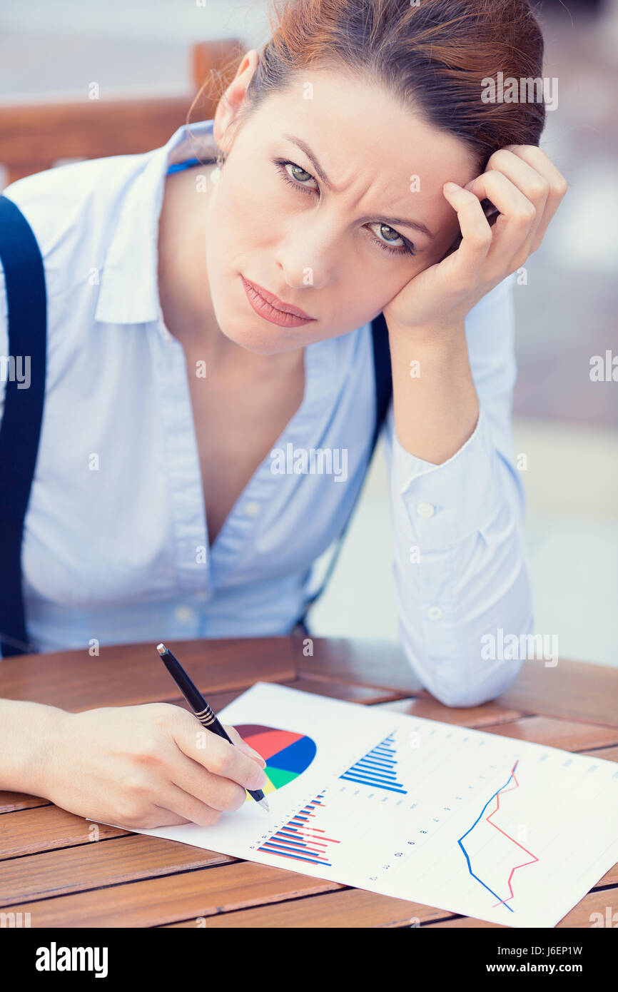 Closeup ritratto infelice donna d'affari in cerca orinato lavorando sulla relazione finanziaria azionista sale riunioni ubicazione nella tabella Documenti, scrittura, distres Foto Stock