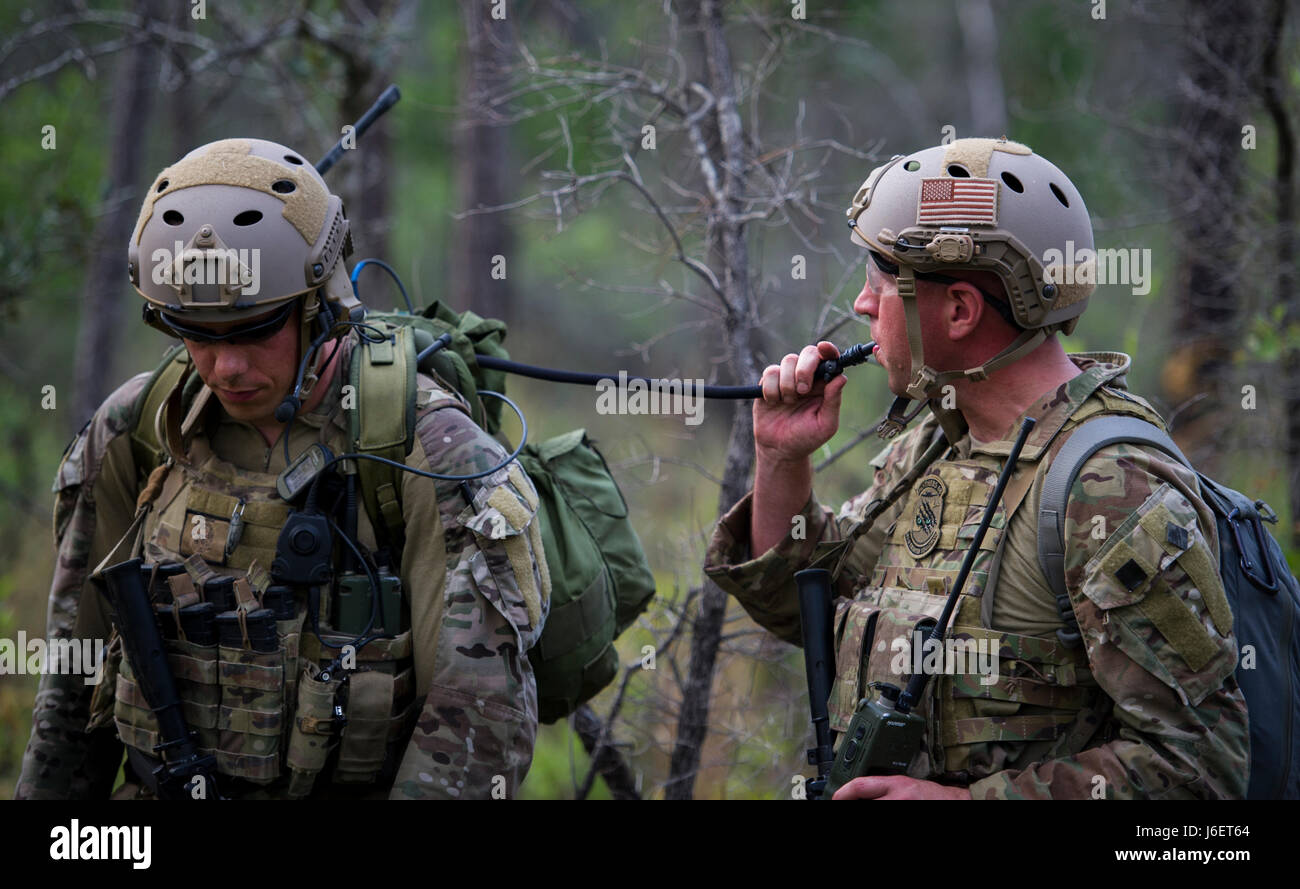 Lt. Col. Benjamin Griffith, a destra, un combattimento aviation advisor con il sesto Special Operations Squadron, bevande acqua da Capt. Cole Geldernick, un CAA con il sesto SOS, durante il funzionamento ad artiglio Raven al duca Campo, Fla., 27 aprile 2017. In tutto Raven artiglio, gli studenti di fronte diversi scenari come la fornitura di pronto soccorso di trattamento per civili locali, gestione di potenziali violazioni dei diritti umani e di reagire alle improvvisate esplosioni durante la notte. (U.S. Air Force foto di Airman 1. Classe Giuseppe Pick) Foto Stock