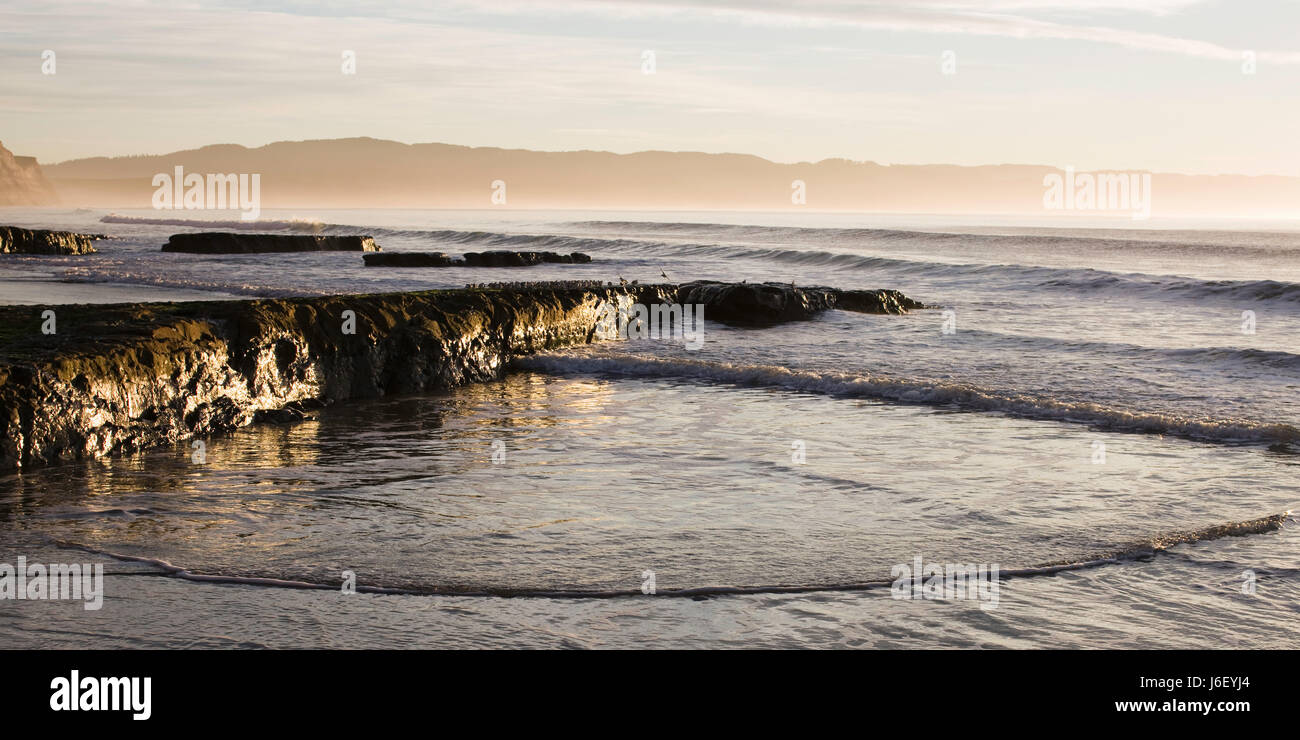 Spiaggia mare spiaggia mare sunrise onde di mattina presto acqua di sale di mare Foto Stock