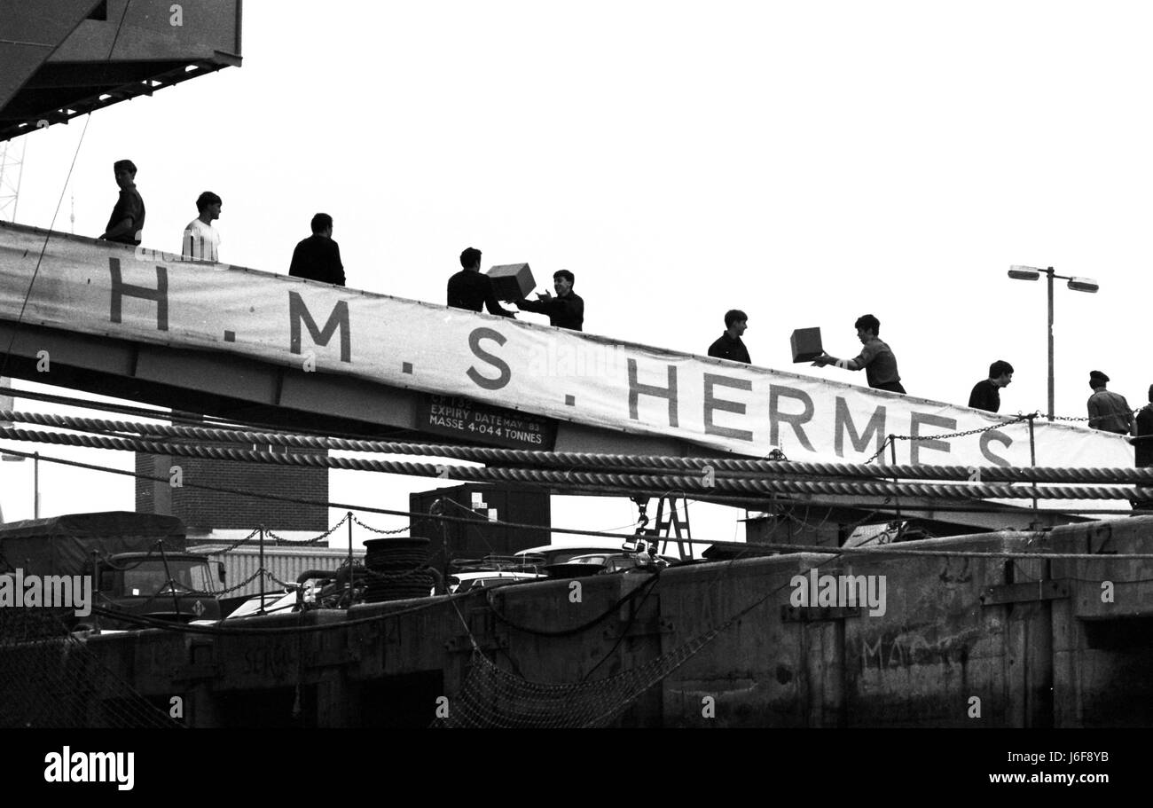 AJAXNETPHOTO. 3RD aprile1982. PORTSMOUTH INGHILTERRA - ISOLE FALKLAND PARTENZA. HMS HERMES CARICHI I NEGOZI COME SI PREPARA A VELA PER IL Sud Atlantico. Foto:JONATHAN EASTLAND/AJAX REF:820304 2 Foto Stock
