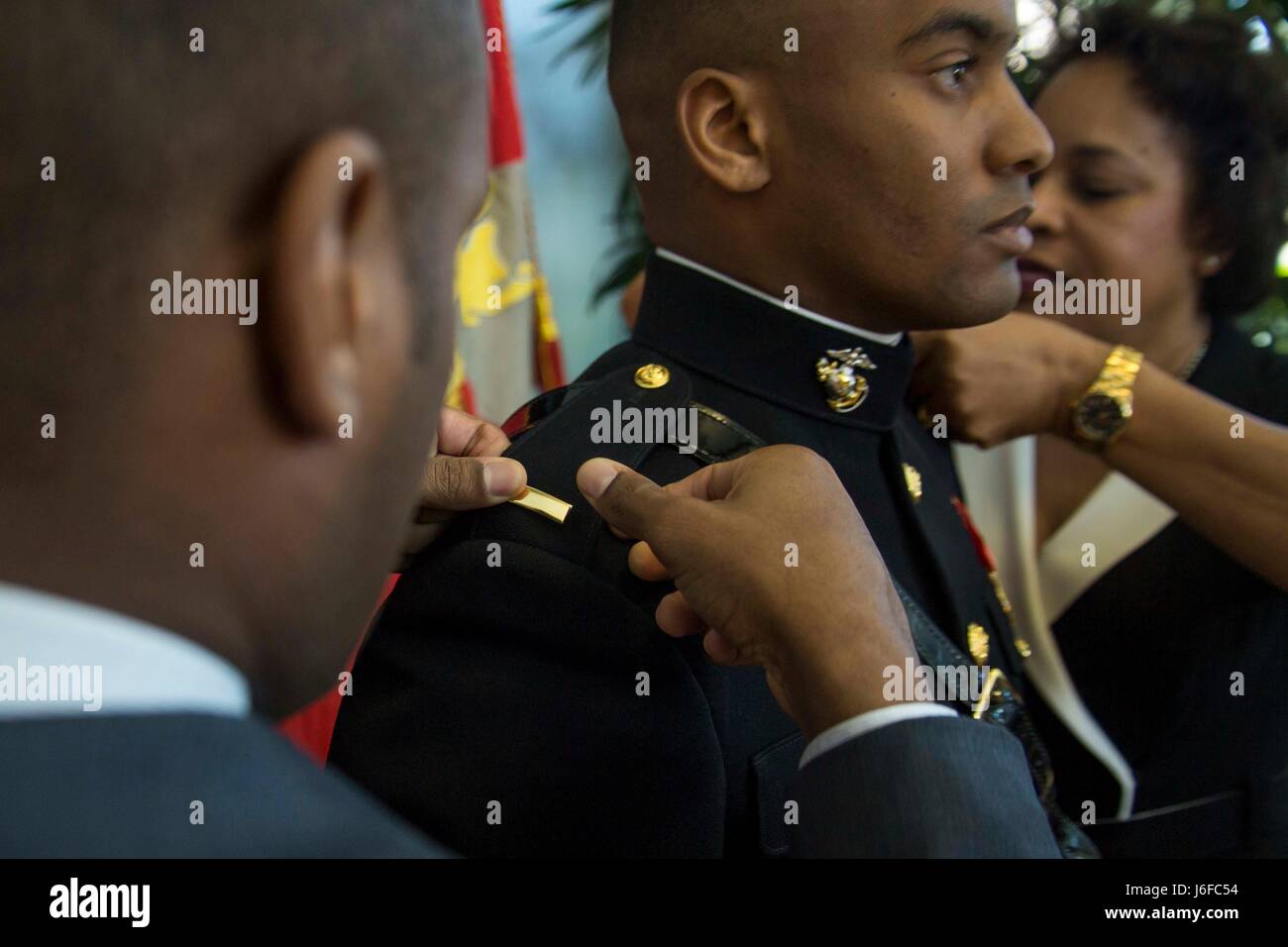 Secondo tenente Mitchell Harrison madre e fratello perno sulle barre che denota il suo rango durante una cerimonia di messa in funzione in corrispondenza di Embry-Riddle università aeronautica's College of Business in Daytona Beach, Florida, 10 maggio 2017. La cerimonia ha commemorato Harrisons' commissione come sottotenente di Marine Corps. Harrison ha completato il 10-la settimana Officer candidati scuola e si prepara a partire per la scuola di base nel luglio 2017. (U.S. Marine Corps photo by Lance Cpl. Martinetto A. E. Rigsby/rilasciato) Foto Stock