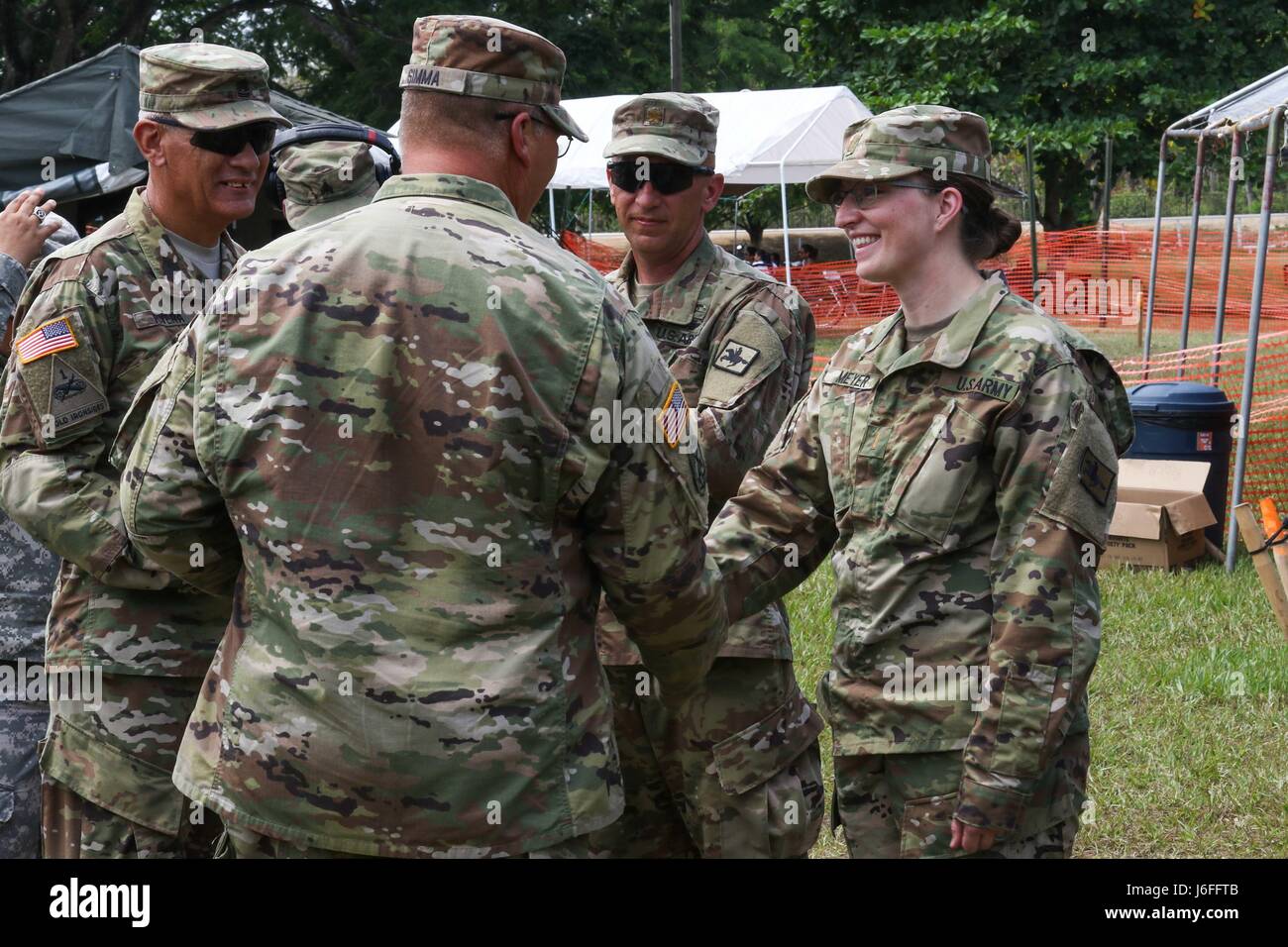 Il comando Sgt. Il Mag. Angelo Rivera e Col. John Simma, che servono entrambi con il 210th regionale gruppo di supporto da Puerto Rico, presente a la festa della mamma regalo al 2° Lt. Danielle Meyer, un Evanston Wyoming nativo, che serve come un infermiere per il Wyoming Guardia Nazionale Medical distacco. Meyer e di uno staff di professionisti medici sono stati la somministrazione di assistenza sanitaria gratuita durante oltre l'orizzonte 2017. (US Army Foto di Sgt. 1. Classe Whitney Houston) Foto Stock