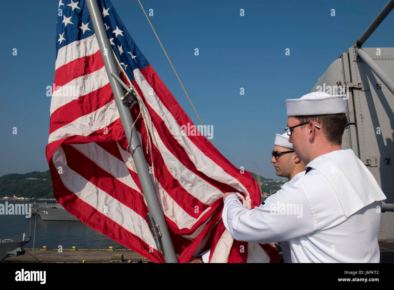 170518-N-NB544-016 Sasebo, Giappone (18 maggio 2017) Aviation Electronics Technician Airman Giacobbe Gonzales (sinistra), da Austin, Texas e Aviation Electronics tecnico di terza classe Patrick Allen, da Cincinnati, condurre i colori del mattino a bordo di un assalto anfibio nave USS Bonhomme Richard (LHD 6). Bonhomme Richard, distribuita a Sasebo, Giappone, serve in avanti per fornire una rapida capacità di risposta in caso di emergenza regionale o calamità naturali. (U.S. Foto di Marina di Massa lo specialista di comunicazione 2a classe Kyle Carlstrom/rilasciato) Foto Stock