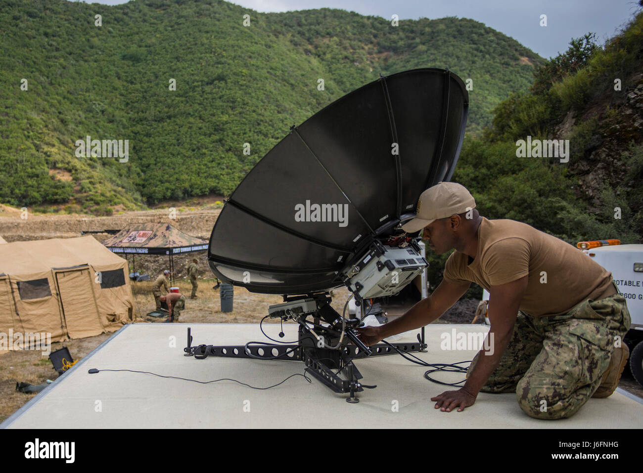 I sistemi di informazione tecnico 1a classe Greg Parker, assegnato alla flotta fotocamera di combattimento del Pacifico (FCCP), stabilisce il collegamento via satellite con la difesa Visual sistema di distribuzione di informazioni durante il FCCP estivo di scatto rapido 2017 esercizio di Azusa, California, 17 maggio 2017. Scatto rapido è un biennale FCCP esercizio che fornisce live-fuoco e le informazioni visive di formazione comune per lottare contro i beni della fotocamera. (U.S. Navy combattere la foto della telecamera tramite la comunicazione di massa Specialist 1a classe Paolo Bayas/rilasciato) Foto Stock