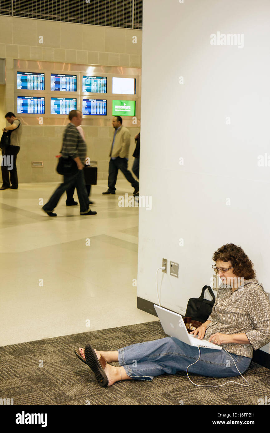 Michigan Wayne County, Detroit, DTW, Detroit Metropolitan Wayne County Airport terminal, gate, arrivo, partenza, compagnie aeree, donna donne, seduta sul Flo Foto Stock