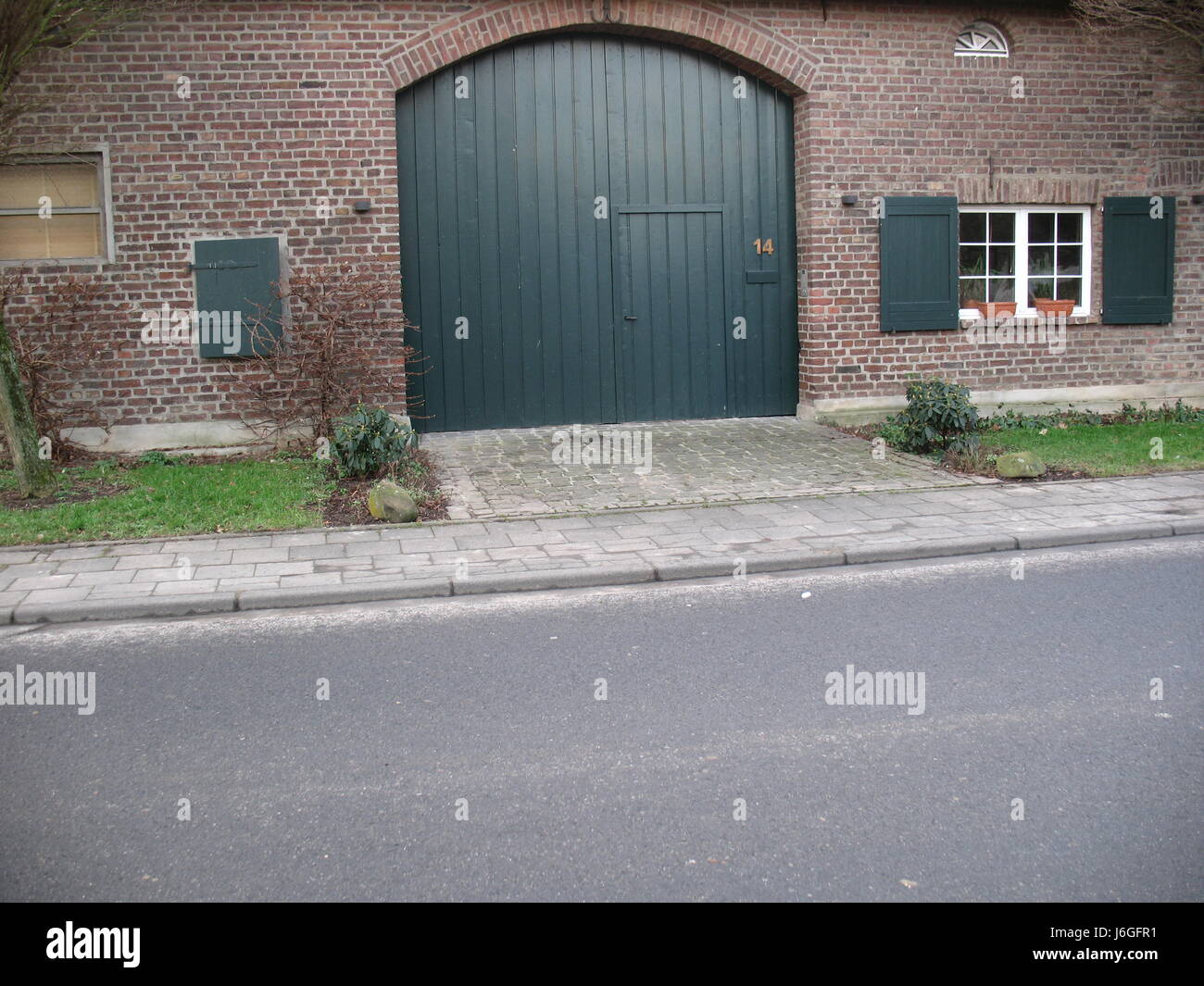 Garage fienile in mattoni clinker ad arco circolare porta di garage house building finestra verde Foto Stock