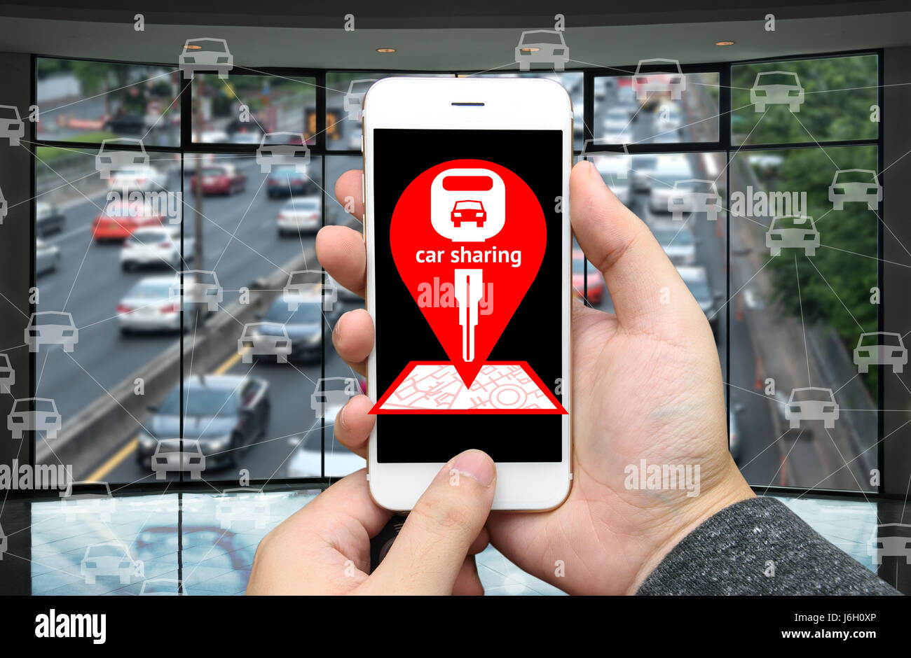Car sharing service o autonoleggio concetto.. Economia di condivisione e consumo collaborativo. Il cliente mano azienda smart phone con icone applicazione sc Foto Stock