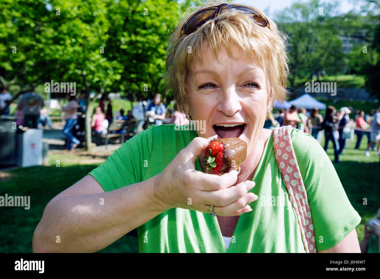Roanoke, Virginia, Elmwood Park, Community School Strawberry Festival, evento annuale, donna, che mangia con fragole ricoperte di cioccolato e si gusta un dessert Foto Stock