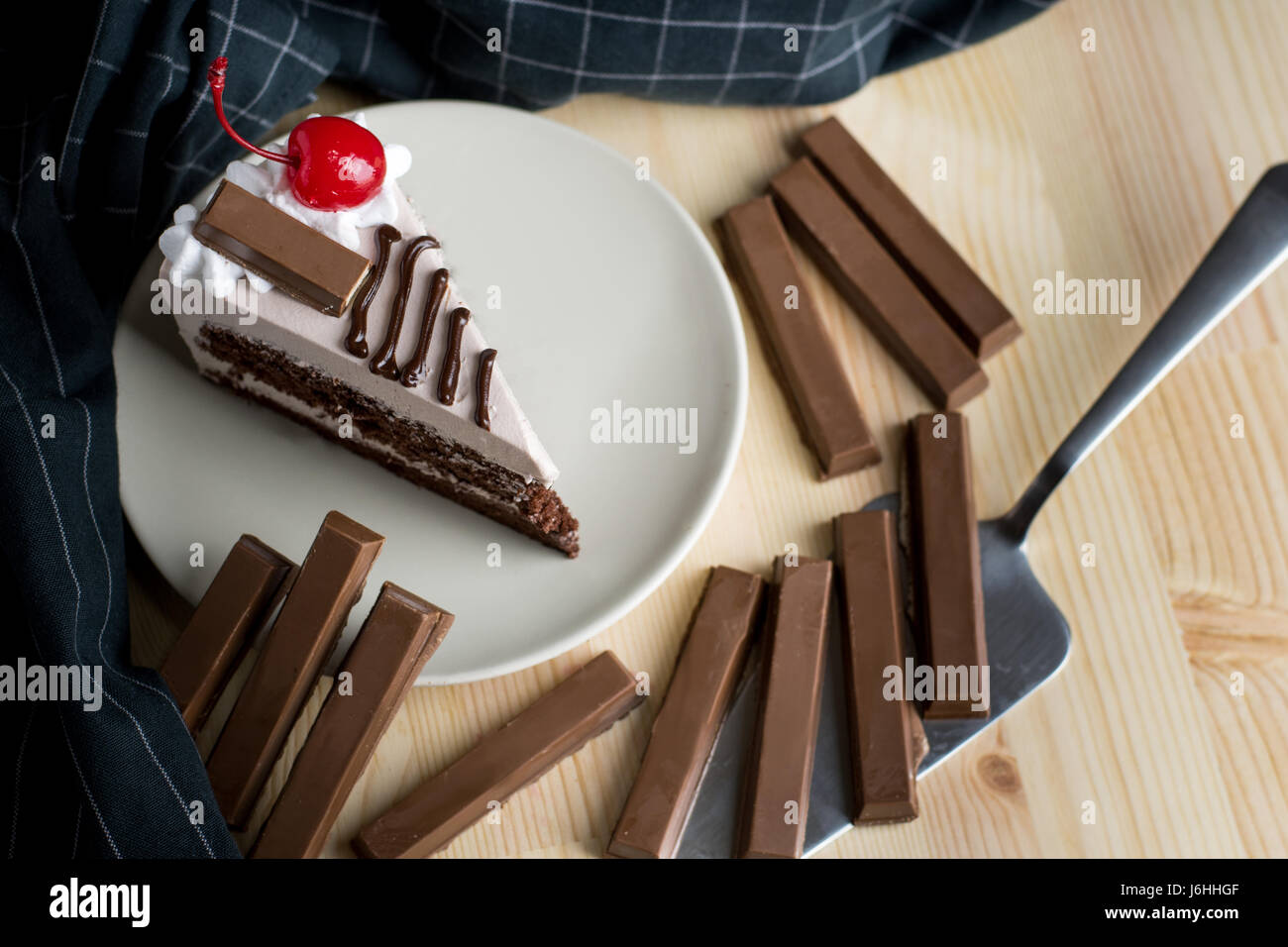 Closeup delizioso dessert al cioccolato fetta ciliegia sulla crema marrone cioccolato torta in spugna sulla piastra bianca ,il fuoco selettivo Foto Stock