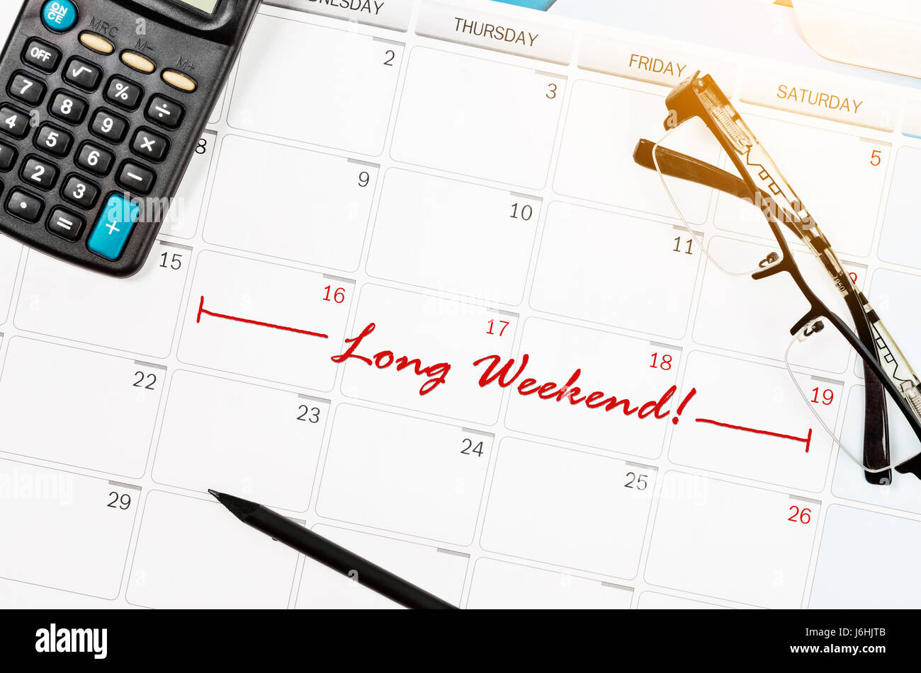 Contrassegnare un lungo weekend sul calendario con occhiali e calcolatrice. Foto Stock