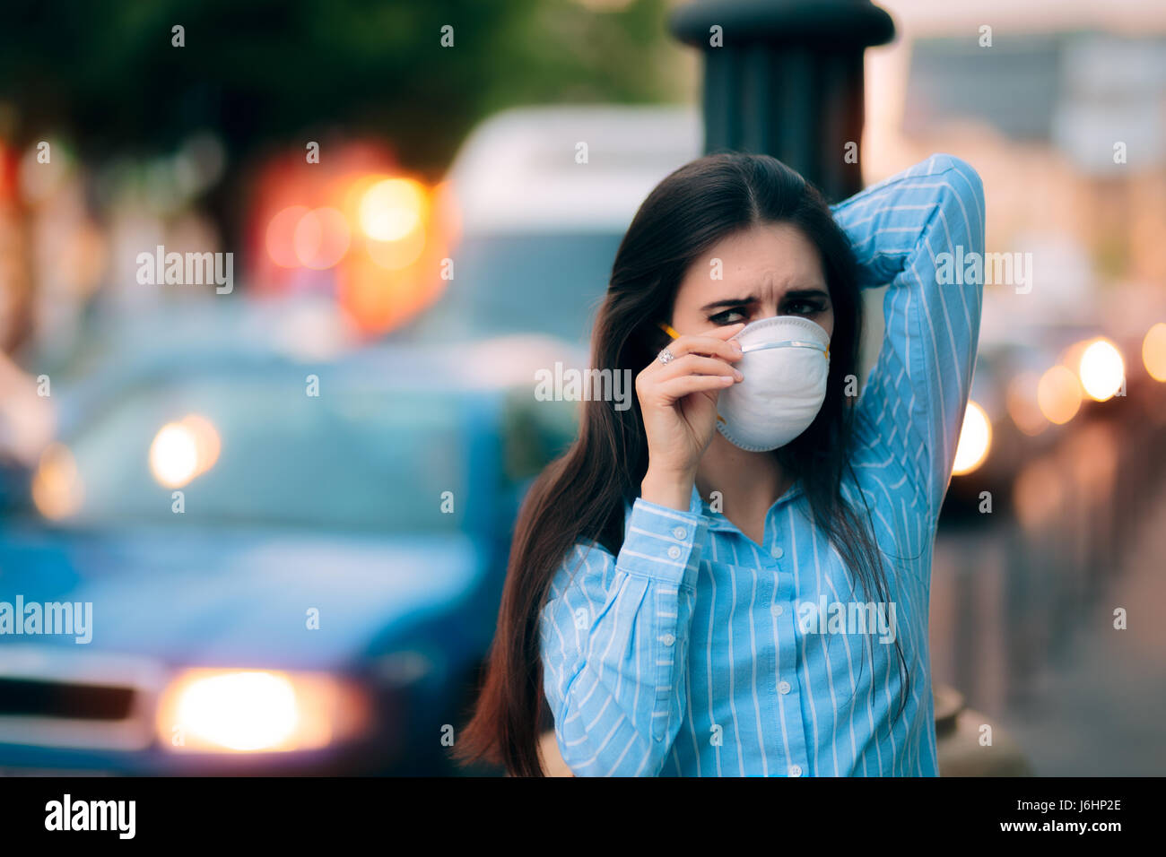 Donna con maschera respiratoria fuori in città inquinate Foto Stock