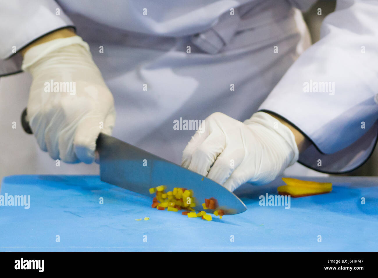 lo chef taglia a mano il cibo in cucina Foto Stock