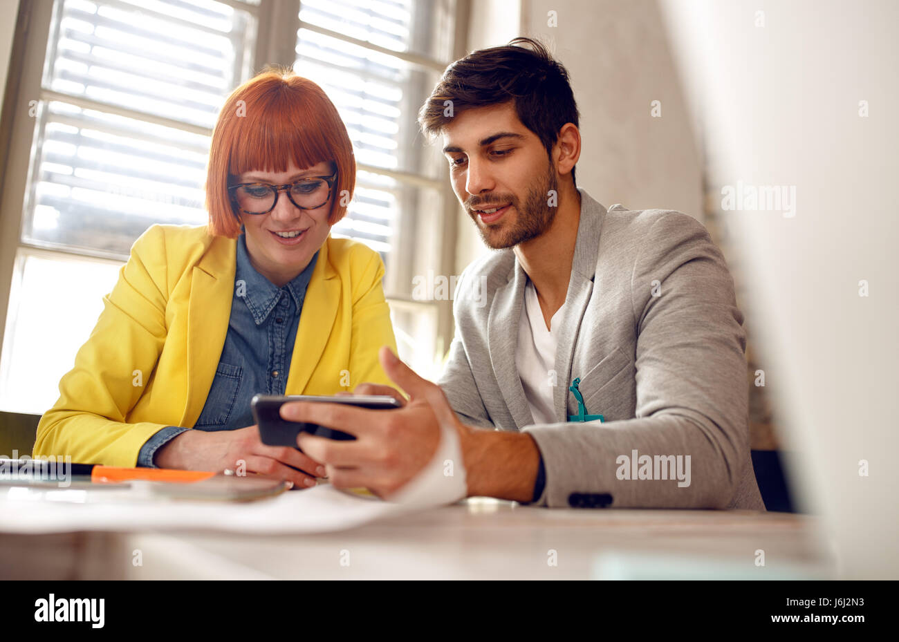 Riunione designer : i colleghi discussione, parlare e condividere idee su smart phone Foto Stock