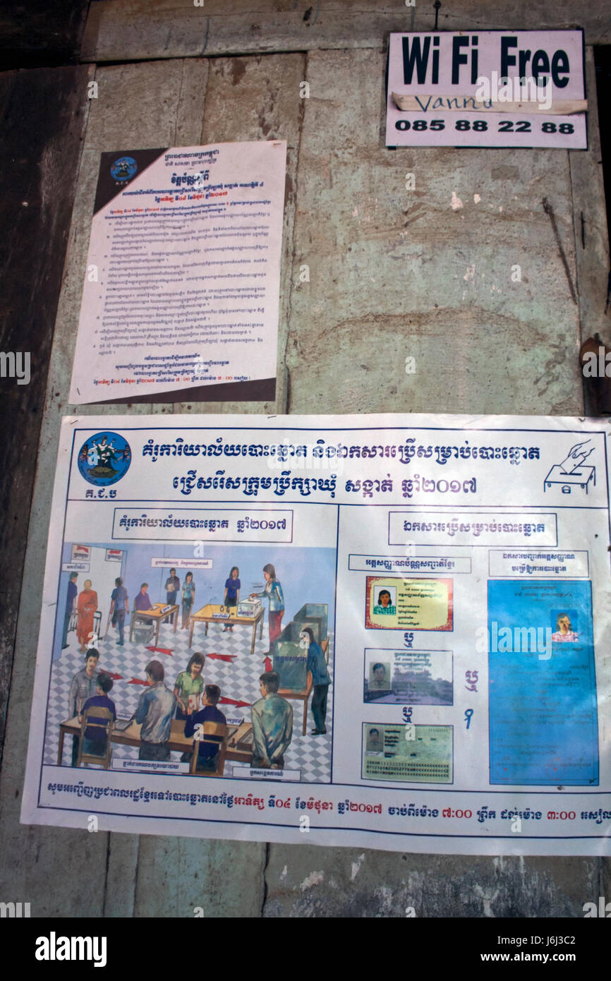 Un poster attaccato ad una parete in corrispondenza di un coffee shop spiega la registrazione degli elettori proceedures nel villaggio di Chork, Tboung Khmum provincia, in Cambogia. Foto Stock