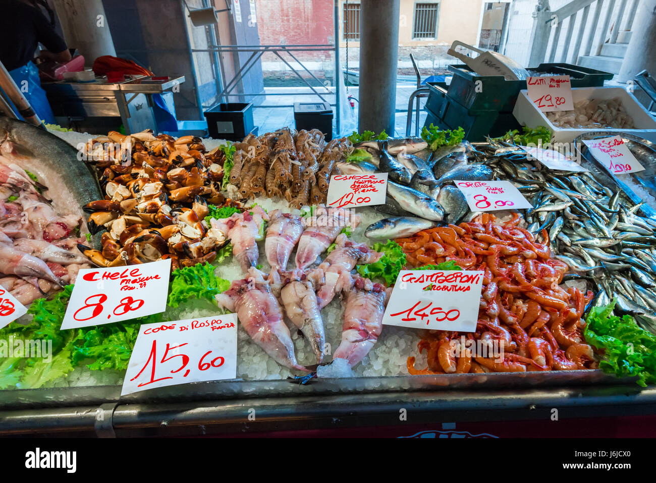Mercato di pesce con il listino prezzi. Pesce fresco, gamberi, granchi e calamari su ghiaccio Foto Stock