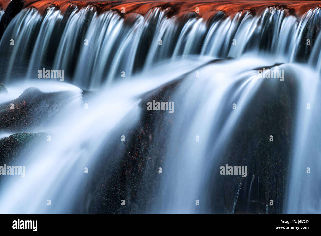 Cascata precipita e pietra con MOSS. Blue flussi di acqua corrente closeup Foto Stock