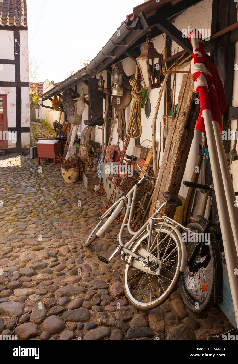 Attrezzature, biciclette e bandiera danese arrotolata in un cortile a Ebeltoft, Danimarca Foto Stock