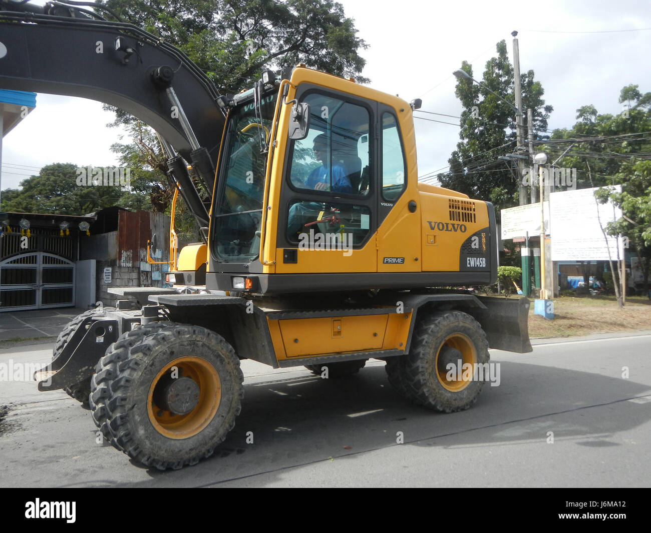 L'immagine mostra la costruzione di strade a Pulilan, Bulacan, concentrandosi sulla Maharlika Highway. Le attrezzature utilizzate, come il Volvo EW146B, sono coinvolte nello sviluppo e nel miglioramento delle infrastrutture delle Filippine. Foto Stock