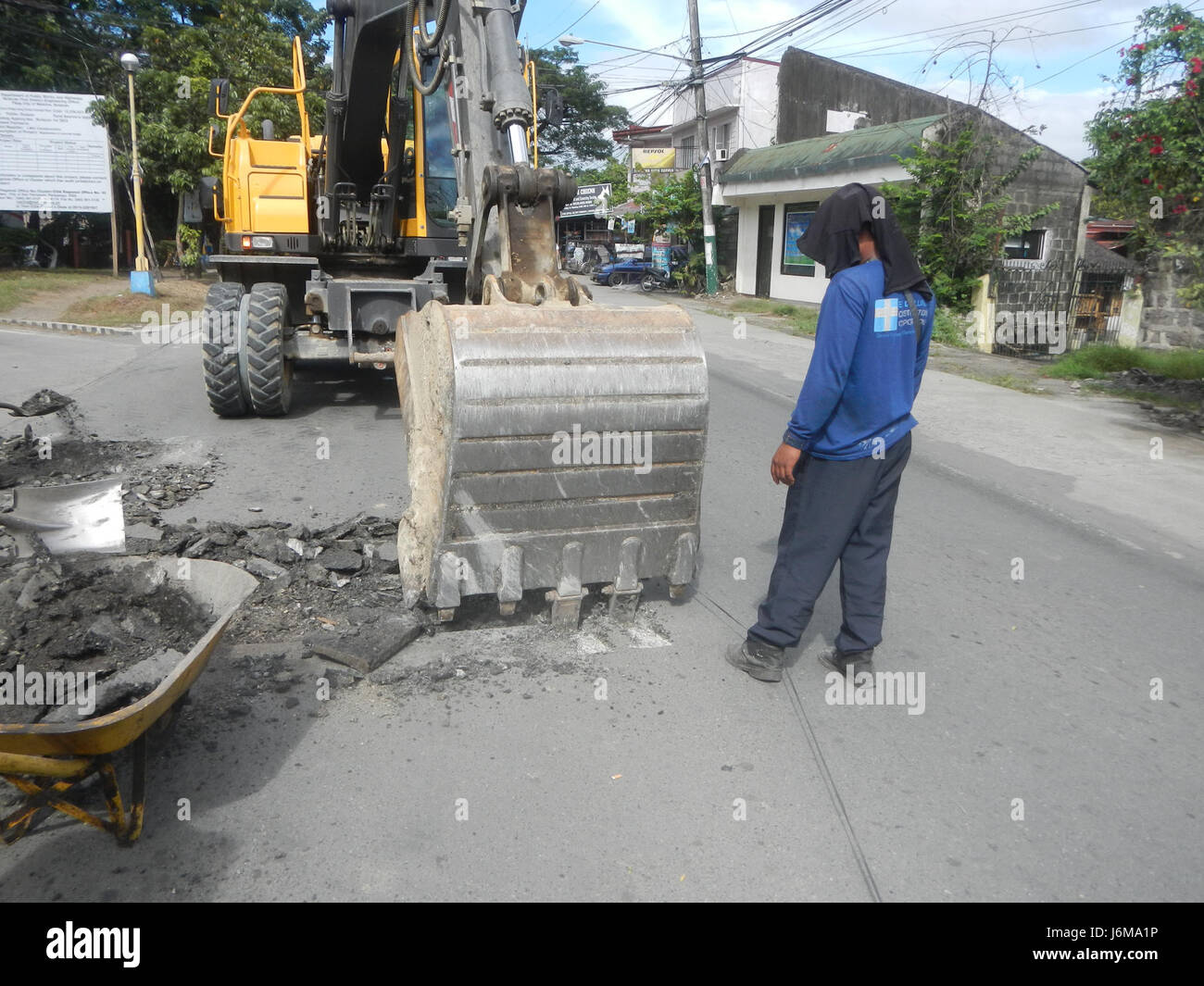 Questa immagine mostra la costruzione di strade a Pulilan, Bulacan, evidenziando l'uso di attrezzature moderne come la Volvo EW165B per progetti lungo la Maharlika Highway. Sottolinea lo sviluppo delle infrastrutture nella regione. Foto Stock
