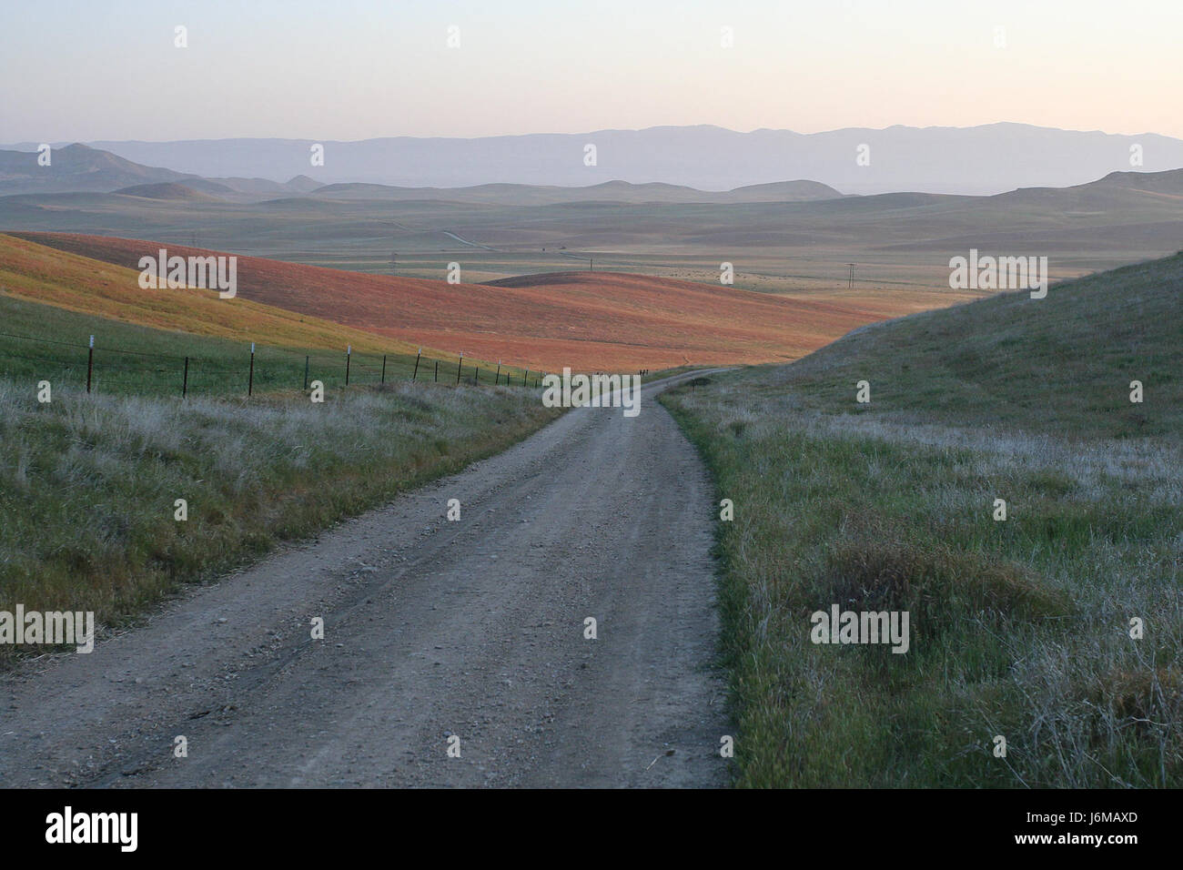 Questa immagine, intitolata "Sunday Morning on the North Gate Road", cattura un momento tranquillo su una strada in un'area rurale o suburbana. L'immagine riflette la tranquillità della mattina in campagna o in una piccola città. Foto Stock