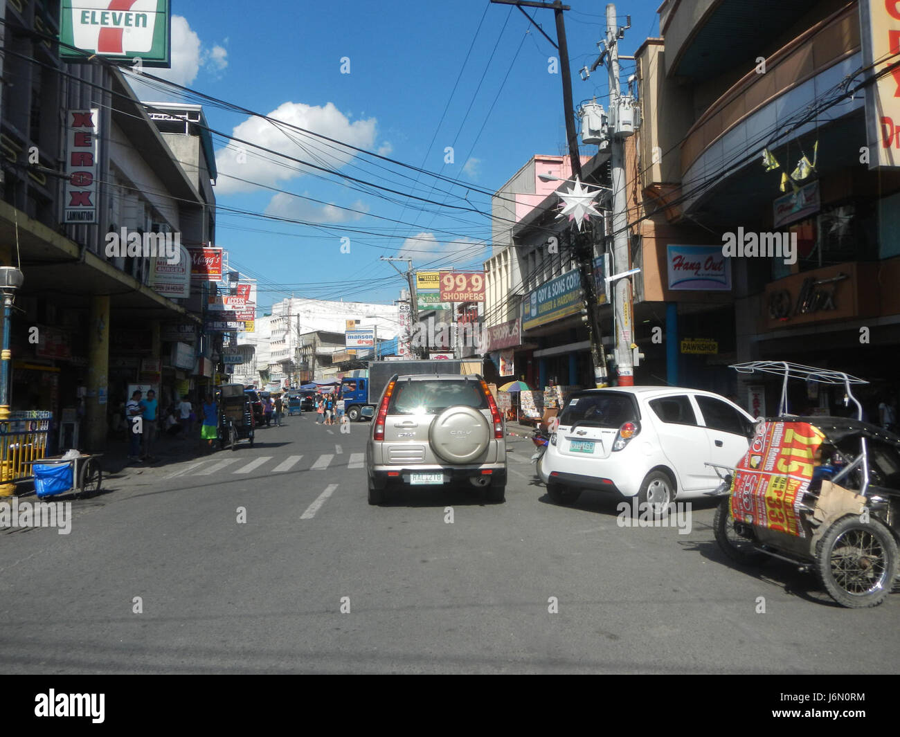 Questa immagine mostra l'area del business center nella città di San Fernando, Pampanga. Le strade sono fiancheggiate da edifici commerciali, che illustrano il ruolo della città come importante centro economico e amministrativo della regione. Foto Stock