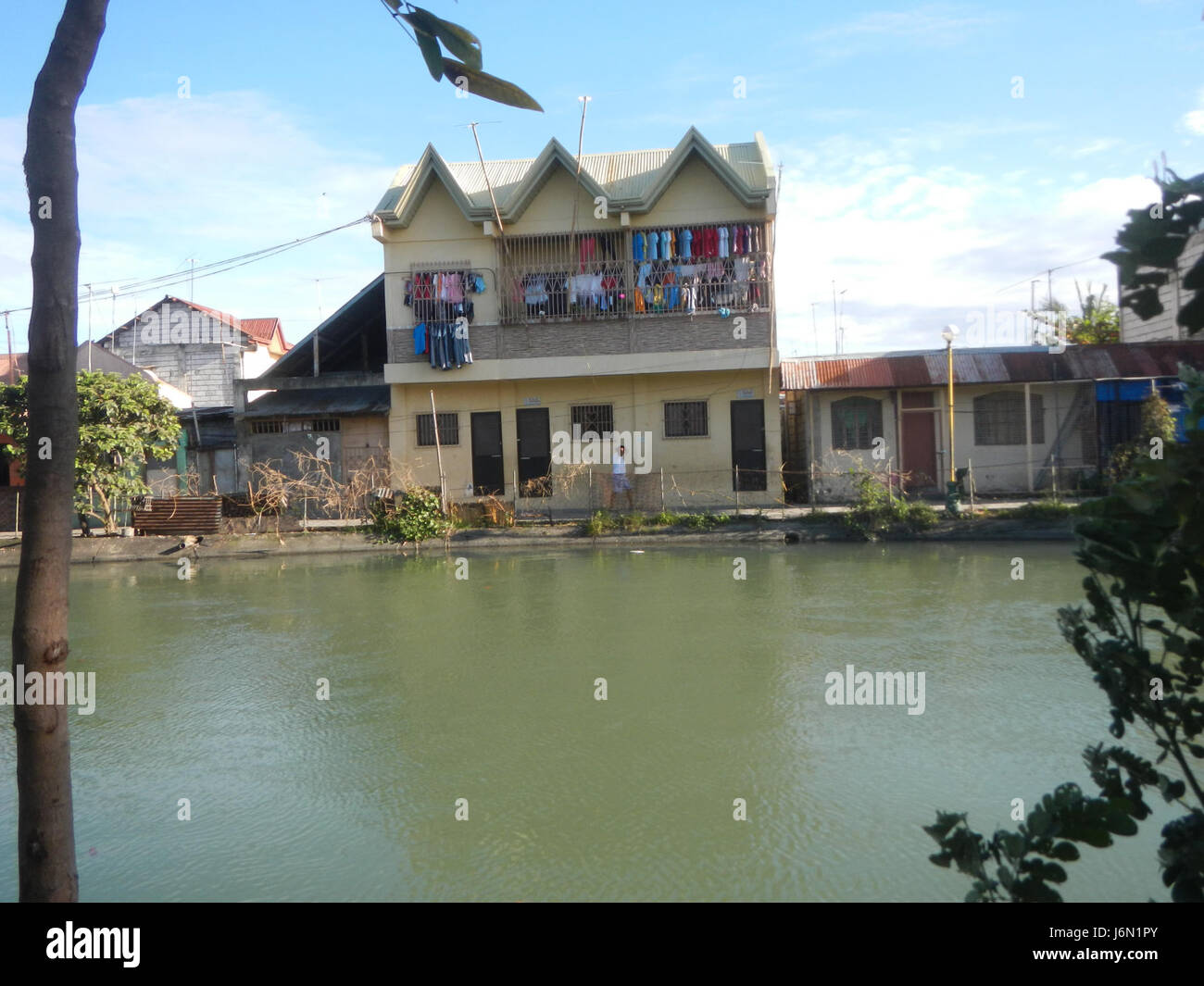 Questa immagine cattura le risaie e il sistema di irrigazione a Bagong Nayon, Baliuag, Bulacan. I campi sono mantenuti con l'aiuto di ponti stradali che facilitano la distribuzione dell'acqua e la coltivazione delle colture nella regione. Foto Stock
