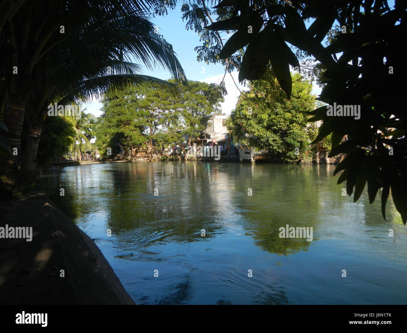 Quest'area di Baliuag, Bulacan, mette in evidenza i paesaggi agricoli con sistemi di irrigazione e infrastrutture stradali, importanti per l'agricoltura e i trasporti locali. Foto Stock