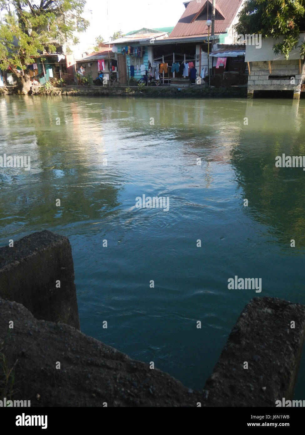 Questa immagine mostra il sistema di irrigazione delle risaie a Bagong Nayon, Baliuag, Bulacan, Filippine, evidenziando i ponti stradali che facilitano la distribuzione dell'acqua. Foto Stock