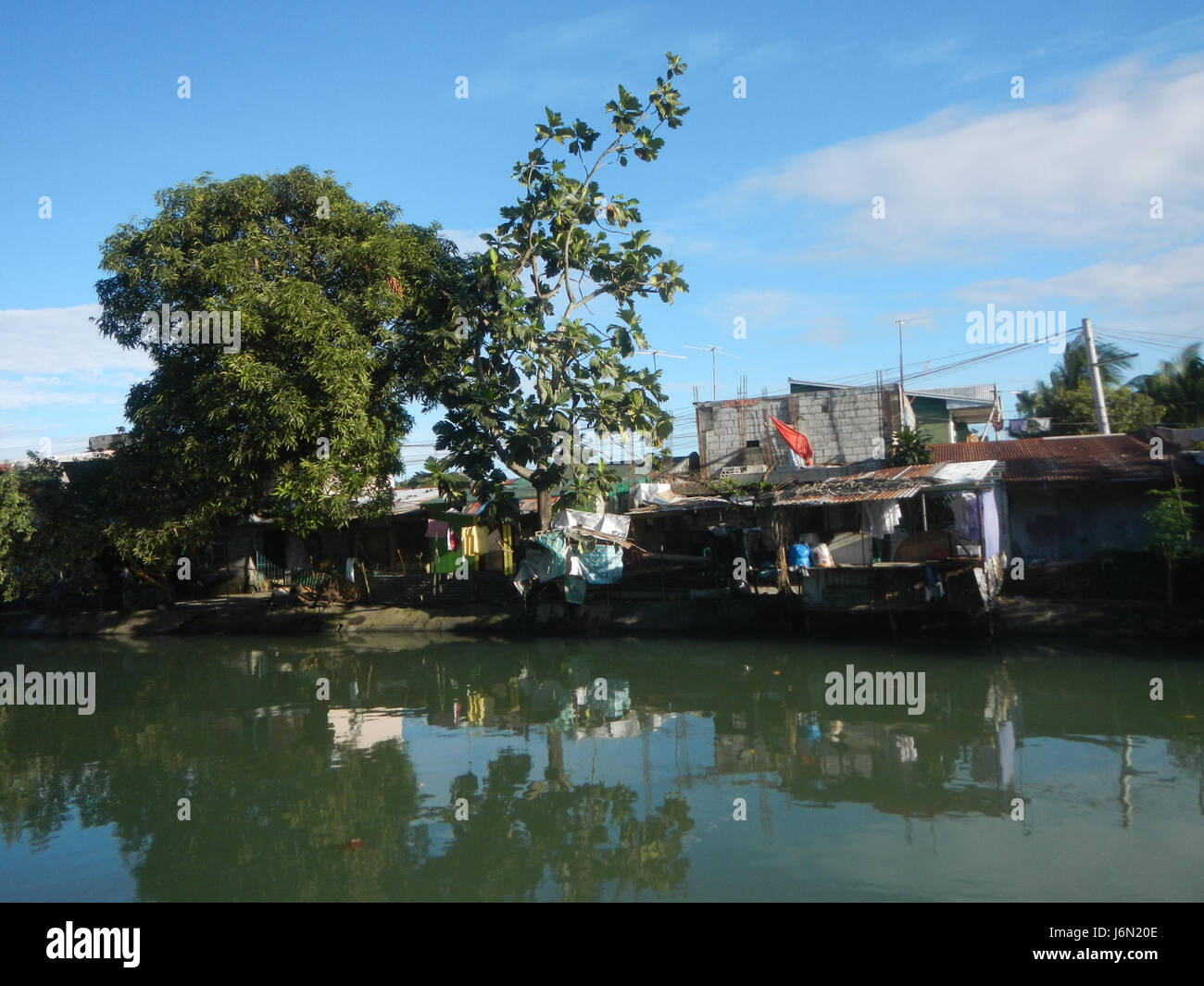 Questa immagine cattura le risaie e i sistemi di irrigazione a Bagong Nayon, Baliuag, Bulacan, mostrando terreni agricoli supportati da ponti stradali per migliorare la connettività e la gestione dell'acqua nella regione. Foto Stock