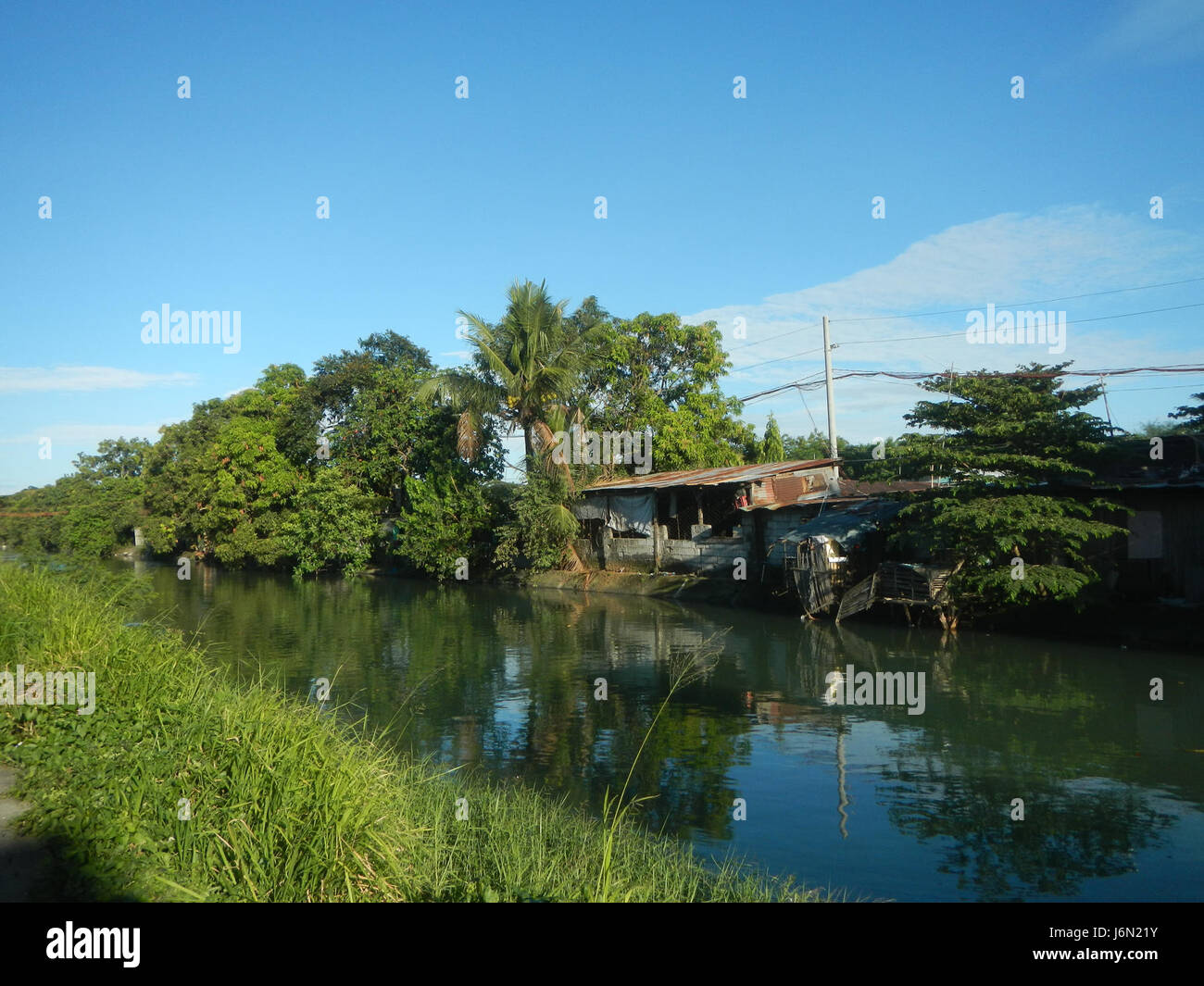 Le risaie e il sistema di irrigazione a Bagong Nayon, Baliuag, Bulacan, sono vitali per l'agricoltura della regione. I ponti stradali contribuiscono a facilitare il trasporto e l'accesso a queste aree agricole cruciali. Foto Stock
