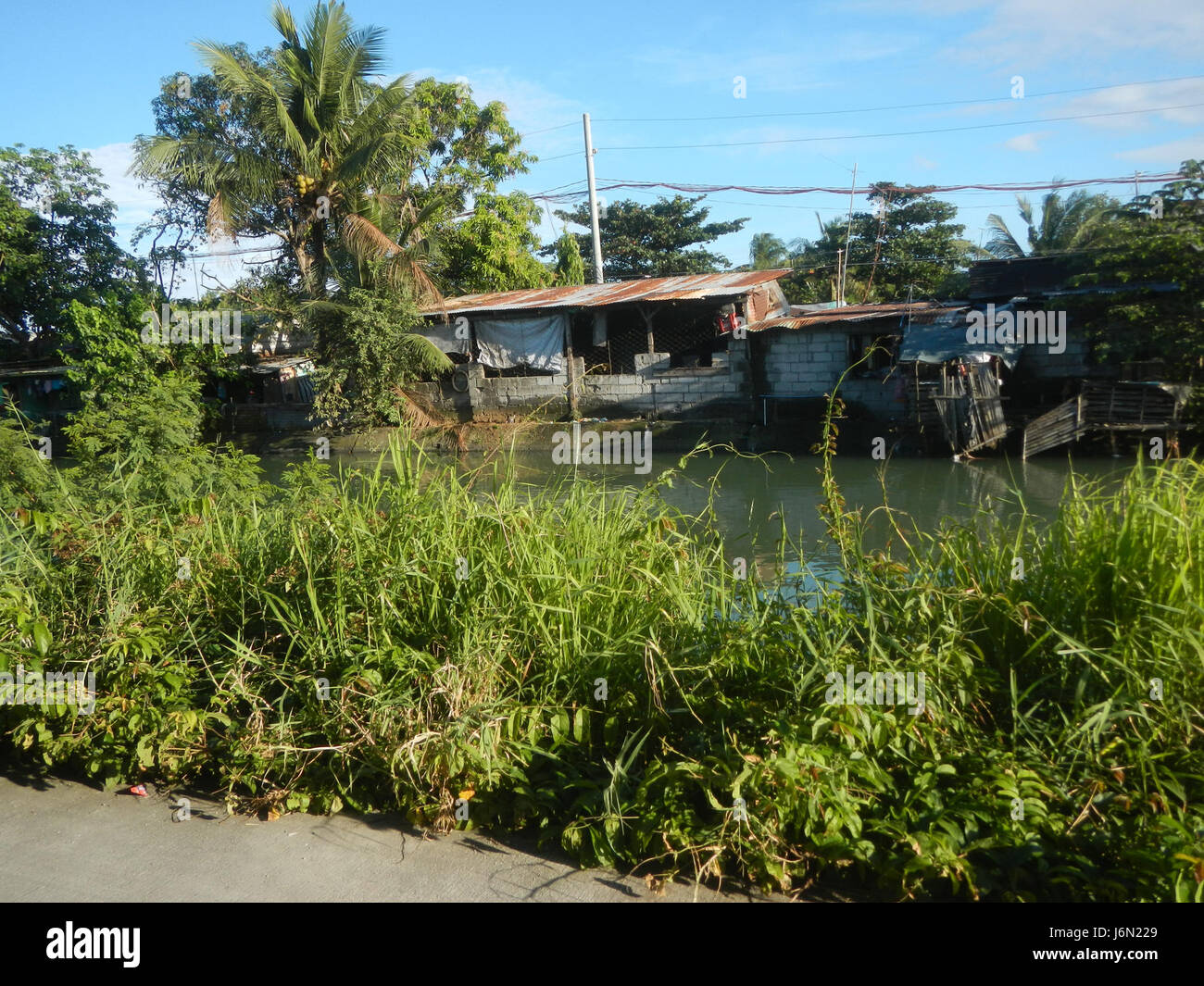 Il sistema di irrigazione delle risaie a Bagong Nayon, Baliuag, Bulacan, svolge un ruolo vitale nell'agricoltura locale. I ponti stradali collegano varie parti della zona, facilitando il trasporto e sostenendo le attività agricole nella regione. Questo sistema sottolinea l'importanza delle infrastrutture nelle comunità rurali. Foto Stock