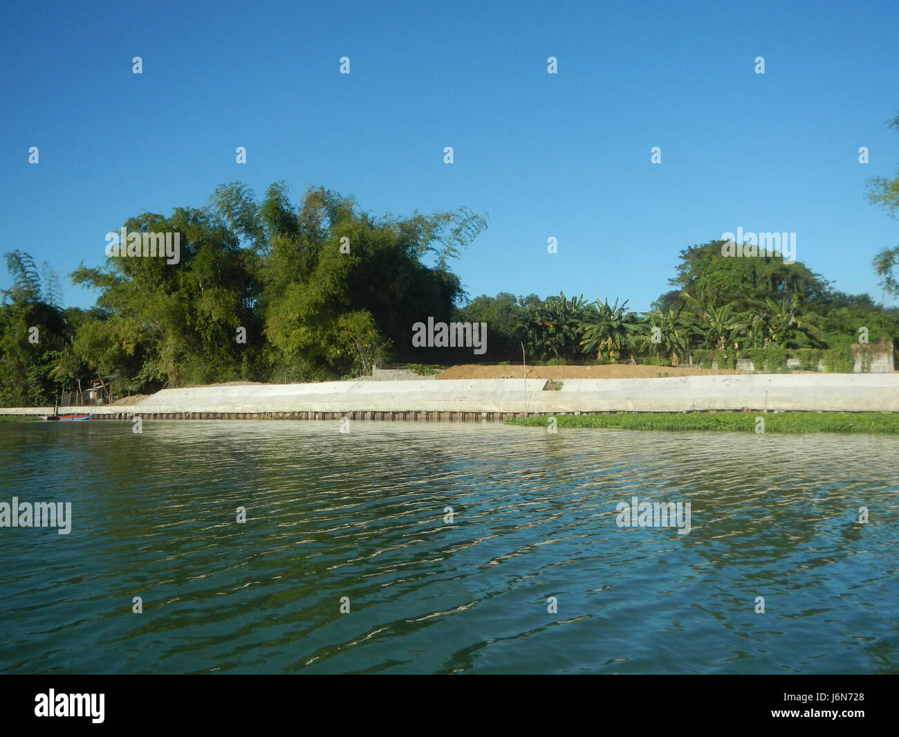 La costruzione di riprap lungo le rive del fiume Plaridel a Pulilan, Bulacan, fa parte di un progetto volto a rafforzare la sponda del fiume per il controllo delle alluvioni e lo sviluppo delle infrastrutture nella regione. Foto Stock