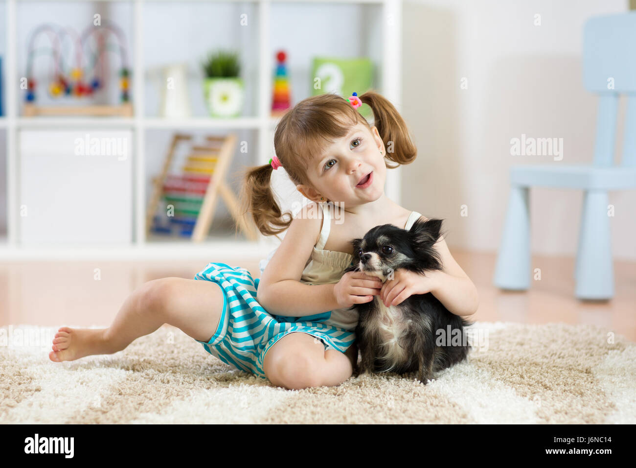 Adorabile bambina gioca con il suo cane Foto Stock